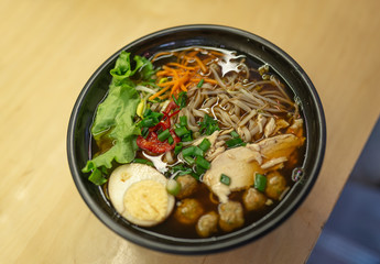 Japan udon noodle soup with egg, salad, paprika and onion.