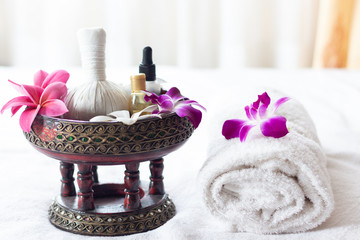 Spa Thai massage accessories in luxury salon on white towel in vase. Oil and beauty care equipment for relaxation and treatment indoors.