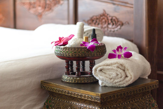 Spa Thai massage accessories in luxury salon on white towel in vase. Oil and beauty care equipment for relaxation and treatment indoors.