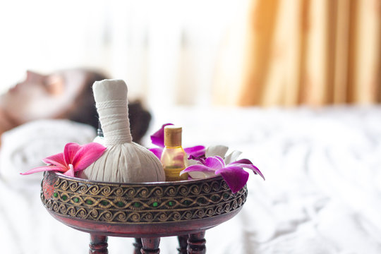 Spa Thai massage accessories in luxury salon on white towel in vase. Oil and beauty care equipment for relaxation and treatment indoors.