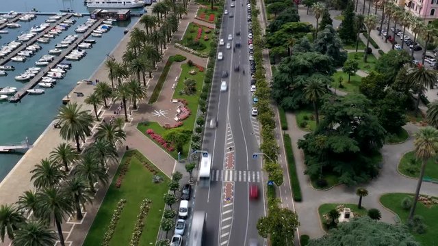 Aerial hyper lapse of a busy road near colorful parks and a harbor
