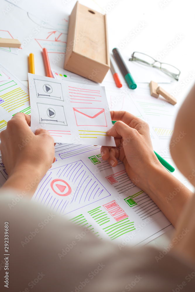 Poster a website designer is working on an application interface. the developer draws sketches of user appl