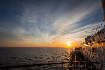 Spectacular sunset over sea horizon seen from the upper deck of a cruise ship