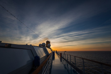 Spectacular sunset over the sea seen from the upper deck of a cruise ship