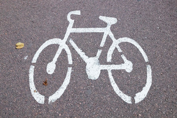 Fototapeta na wymiar White picture bike on the bicycle path. Bicycle road sign on asphalt.