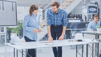 In the Industrial Engineering Facility: Young Female Designer Works with Chief Industrial Engineer,...