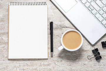 Flat lay overhead of office desk with blank notepad, laptop and cup of coffee. Business or education concept.