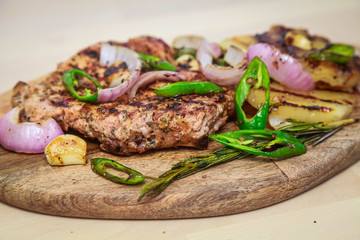 Grilled pork with pineapple, red onion and hot green pepper. Serve on a wooden board.