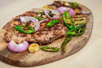Grilled pork with pineapple, red onion and hot green pepper. Serve on a wooden board.