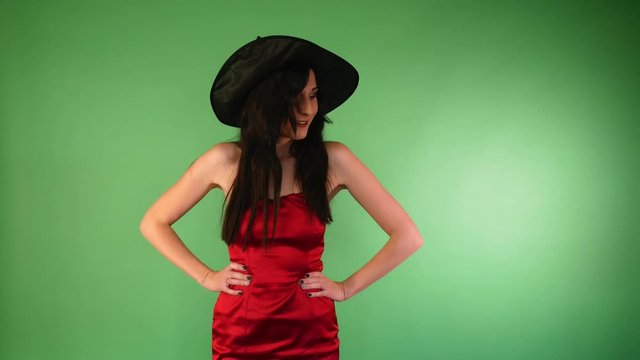 young beautiful woman in red dress and witch hat dancing. Halloween concept.4k