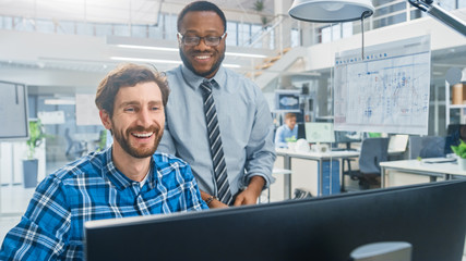 In the Industrial Engineering Facility: Portrait of the Handsome Male Engineer Working on Desktop...