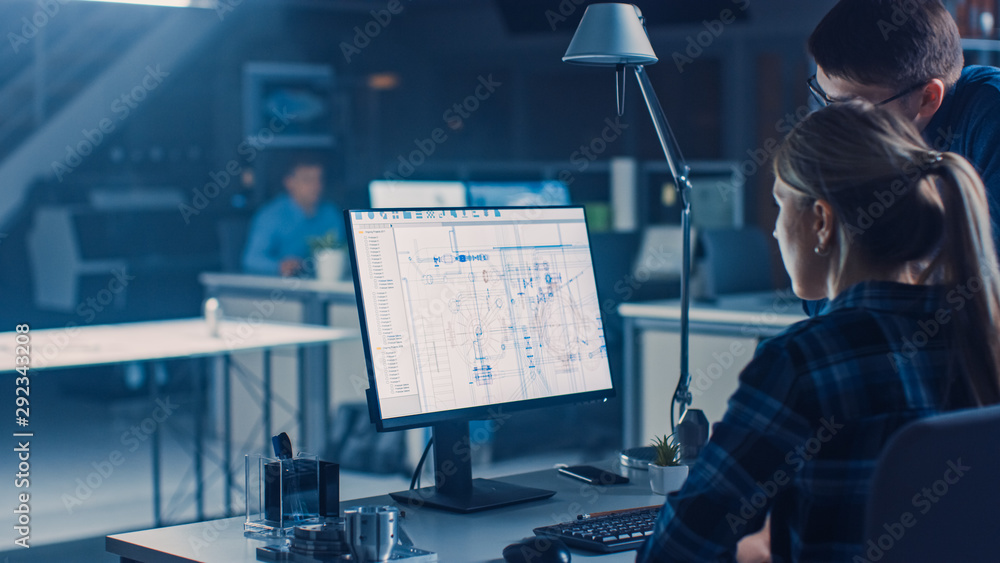 Poster Engineer Working on Desktop Computer, Screen Showing CAD Software with Technical Blueprints, Her Male Project Manager Explains Job Specifics. Industrial Design Engineering Facility Office