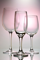 Glasses for different types of alcohol and different capacities on a pink background.