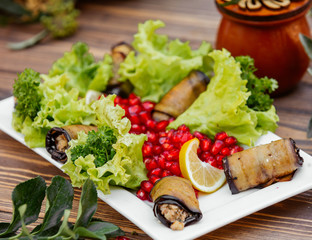 Fried aubergine wraps with minced meat and fresh herbs, lemon, lettuce, pomegranate