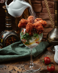 Fried crispy shrimp cocktail with parsley in a glass