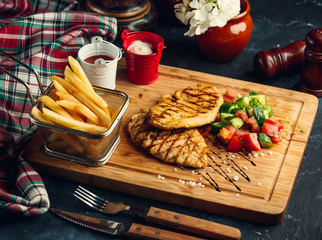 Grilled chicken fillet serve with fresh salad and french fries, mayo and ketchup