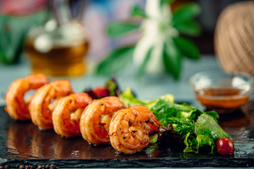 Grilled shripm with fresh herbs salad on black stone board