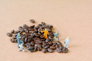 Fototapeta na wymiar Group of teamwork miniature people, small model human figure cleaning coffee beans on wooden table. Copy space. Food and beverage concept.