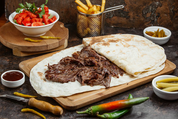 Lamb steak doner in flatbread served with fresh tomato and cucumber salad