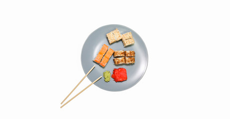 Sushi on the plates with chopsticks isolated on white background. Salmon, wasabi and ginger. Healthy food concept. Japanese dinner. Vegetarian.