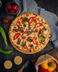 Mix pizza with tomato slices, mushroom, olive, basil leaves, and minced meat