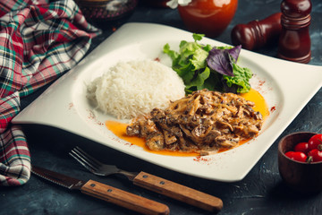 Sauteed mushroomwith rice and fresh salad on white plate