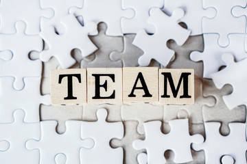 teamwork for business,finance and marketing concept with text on jigsaw puzzle background 