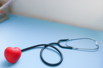 Red heart with doctor's stethoscope on blue background and copy space, healthcare medical concept