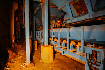 Abandoned brick factory at night. Old rusty brick forming machine and conveyor belt