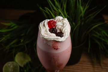  Berry refreshing smoothie with cream on a green background