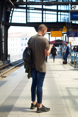 man using smartphone in a train station in Berlin.