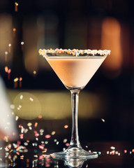 Close up of iced drink in martini glass decorated with colourful sprinkles