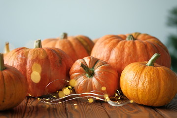 pumpkins with a shining garland on a wooden table