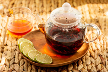 Welding of black tea in a glass teapot. Tea Party with Honey and Lime
