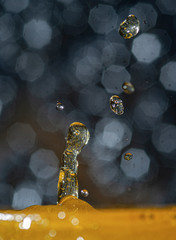 Frozen drops & splash of colored water liquid in high speed photography with a beautiful bokeh in the background