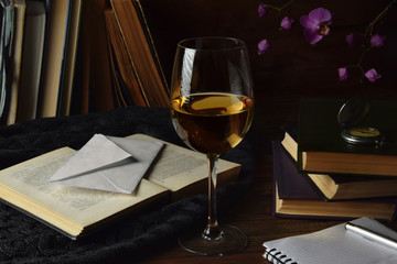 Glass of wine, letter, books