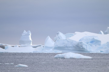 wystające ponad taflę wody wierzchołki gór lodowych oraz kry przy wybrzeżu antarktydy