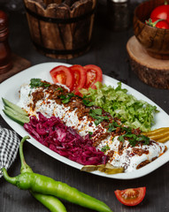 Turkish adana kebab with minced meat served with yoghurt and salads
