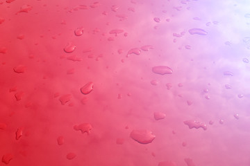 Drops of water on a red surface, toned