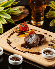 Two pieces of round small steaks with pomegranate sauce and grilled vegetables
