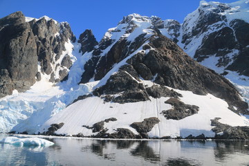 spokojne zimne wody pomiędzy ośnieżonymi skałami u wybrzeży antarktydy w piękny słoneczny...