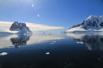 spokojne zimne wody pomiędzy ośnieżonych skałami u wybrzeży antarktydy w piękny słoneczny...