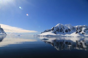 Fototapeta na wymiar spokojne zimne wody pomiędzy ośnieżonych skałami u wybrzeży antarktydy w piękny słoneczny dzień