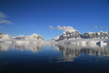 skaliste i ośnieżone wybrzeże antarktydy w słoneczny dzień © KOLA  STUDIO