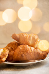 Festive Christmas or New Year pastries, sweet croissants, Christmas sweets. Christmas mood. Christmas lights. Winter Holidays Concept. Light background. Selective focus