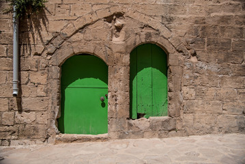 Fototapeta na wymiar Two doors of stone wall. One is steel other is wooden.