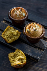 Pumpkin muffins on a dark wooden and half a broken cupcake