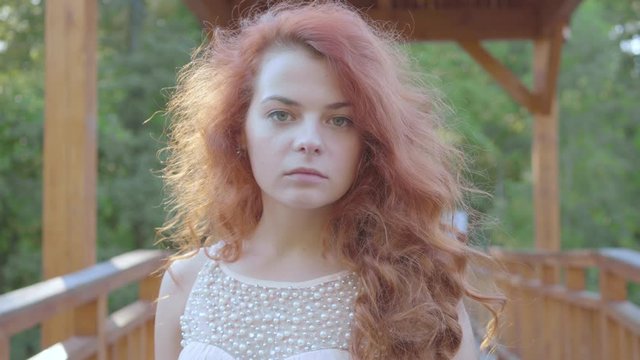 Incredibly beautiful caucasian woman with red hair turning around and looking at the camera. Natural prettiness of a young readhead girl.