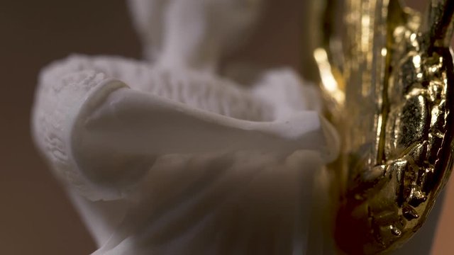Closeup on a white marble statue of the Greek god Apollo. Panning from down to high.