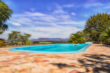 Pool with mountainous landscape and pastures in the background in Paraguay..
